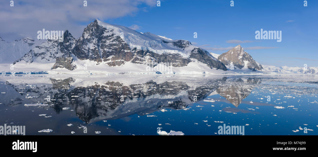 Belle scenic Pan enneigés des Glaciers et falaises reflètent dans les eaux du Canal Lemaire encore l'Antarctique, Écart Kodiak au large de la péninsule Antarctique Banque D'Images