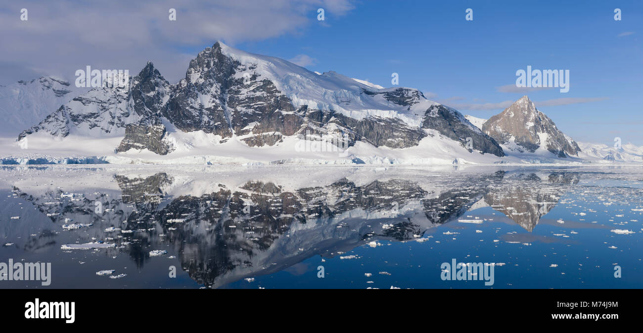 Belle scenic Pan enneigés des Glaciers et falaises reflètent dans les eaux du Canal Lemaire encore l'Antarctique, Écart Kodiak au large de la péninsule Antarctique Banque D'Images