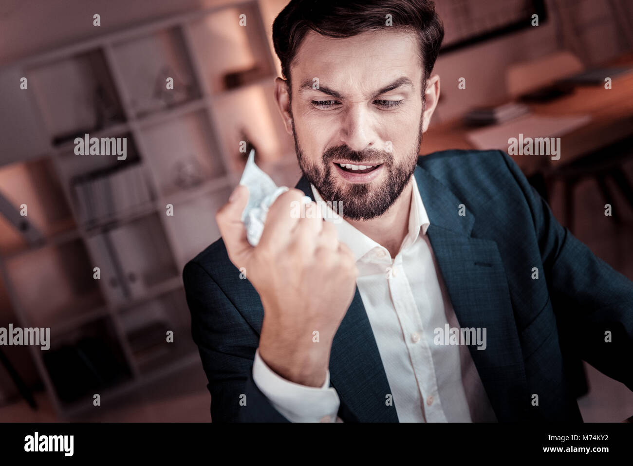 Angry insatisfait worker holding et frappe le document. Banque D'Images