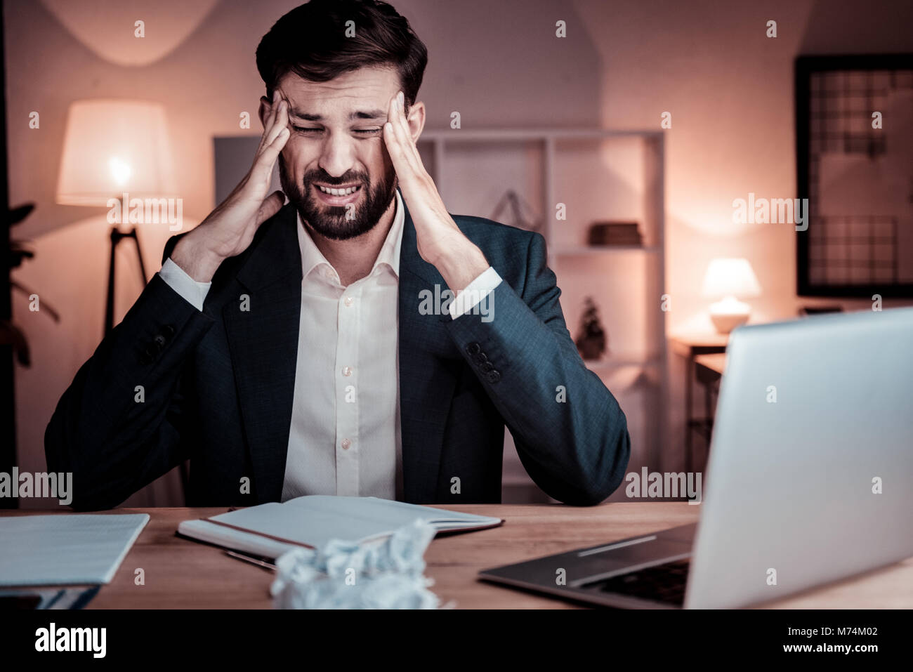 Mauvais homme assis inébranlable et d'avoir mal de tête. Banque D'Images