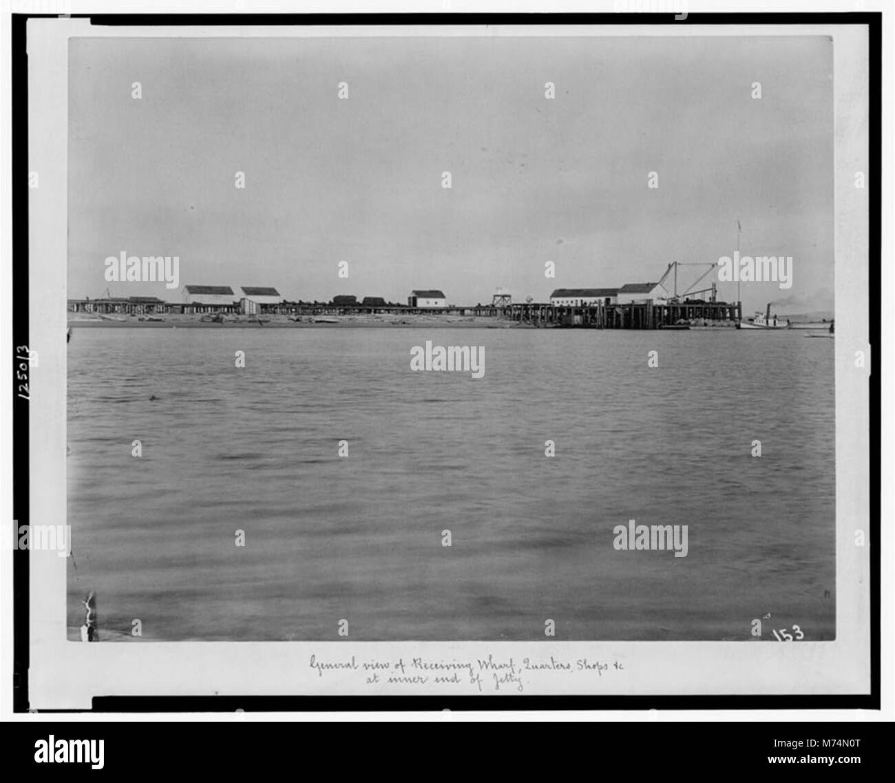 Cette image fournit une vue générale du quai de réception, des quartiers, des magasins et d'autres installations situés à l'extrémité intérieure d'une jetée. La scène reflète l'importance de l'infrastructure maritime pour le commerce et le transport au début du XXe siècle. Banque D'Images