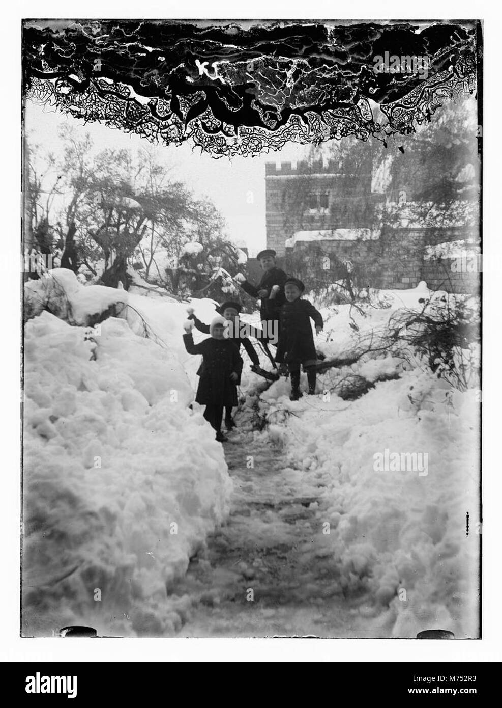 Photographie de Jérusalem recouverte de neige, prise en 1921. Cette scène hivernale rare capture la ville historique avec ses bâtiments emblématiques et ses rues recouvertes de neige, mettant en valeur le contraste entre la ville antique et le paysage enneigé. Banque D'Images