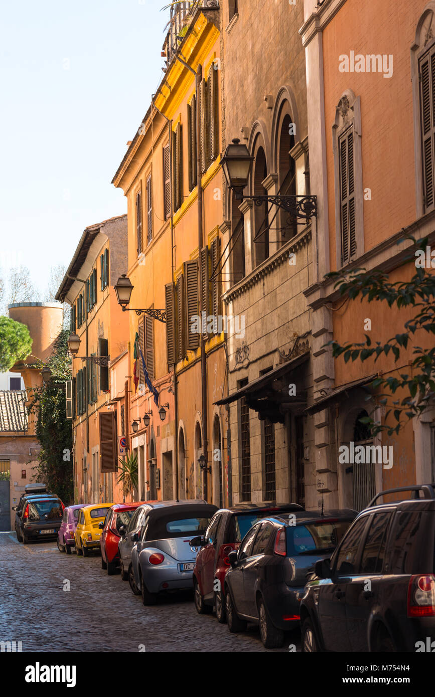 Backstreet Trastevere avec des voitures en stationnement et colorée des bâtiments rustiques. Rome, Latium. L'Italie. Banque D'Images
