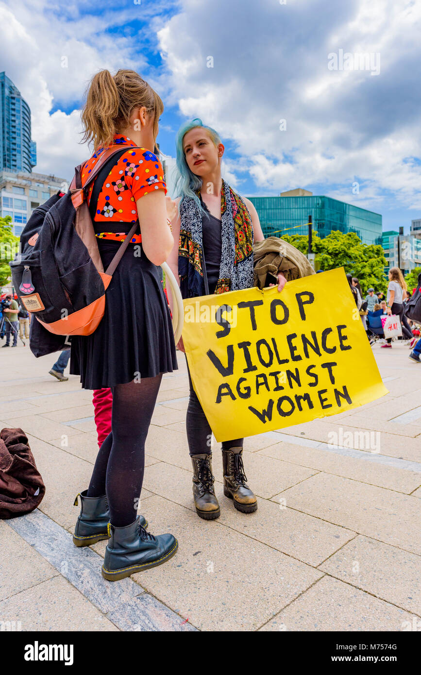 Femme avec Stop à la violence contre les femmes, signe , le centre-ville de Vancouver, Colombie-Britannique, Canada. Banque D'Images