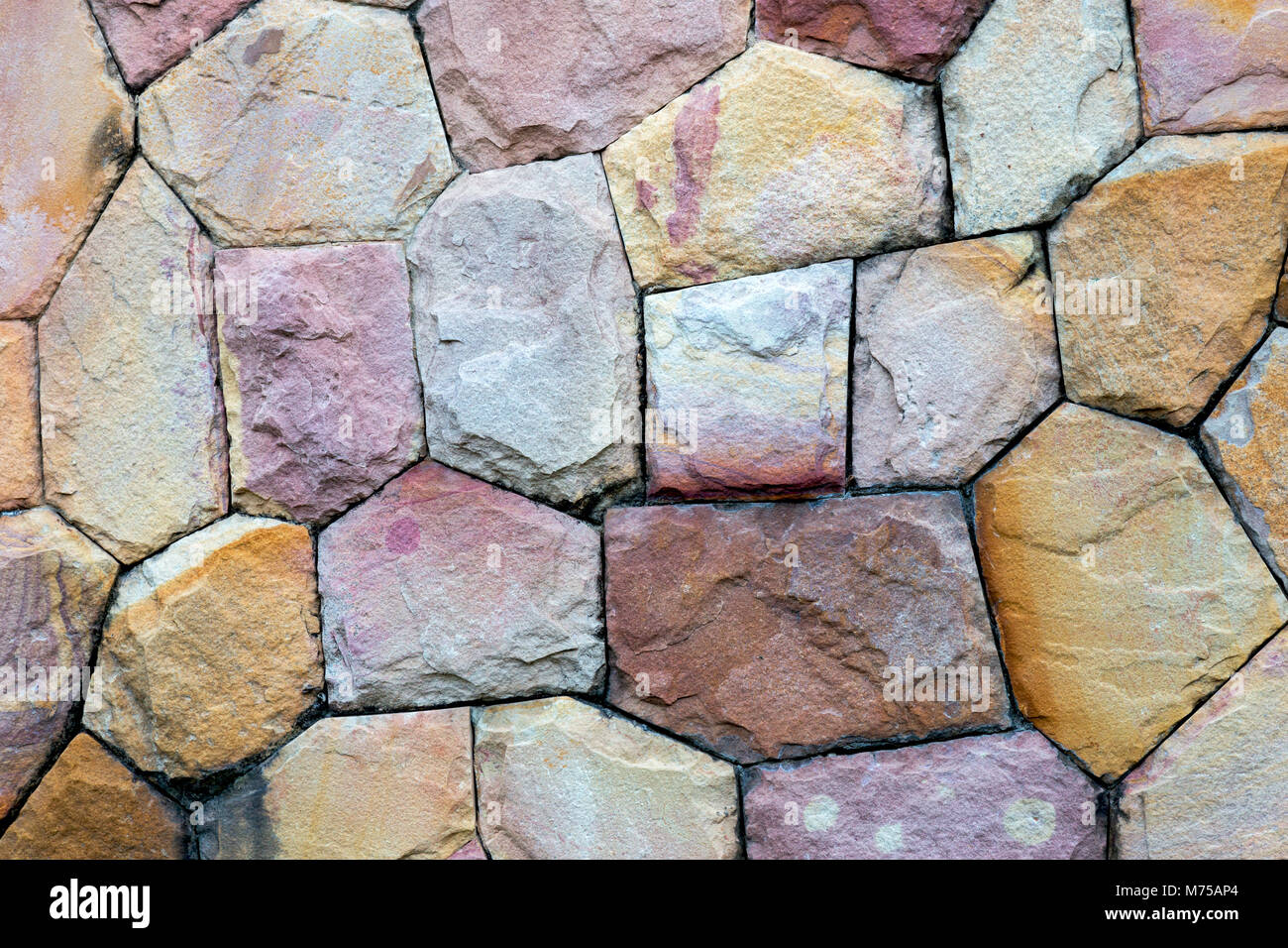 Mur de pierre est construit de belles pierres naturelles multicolores de différentes tailles, de roches. contexte et papier peint. Banque D'Images