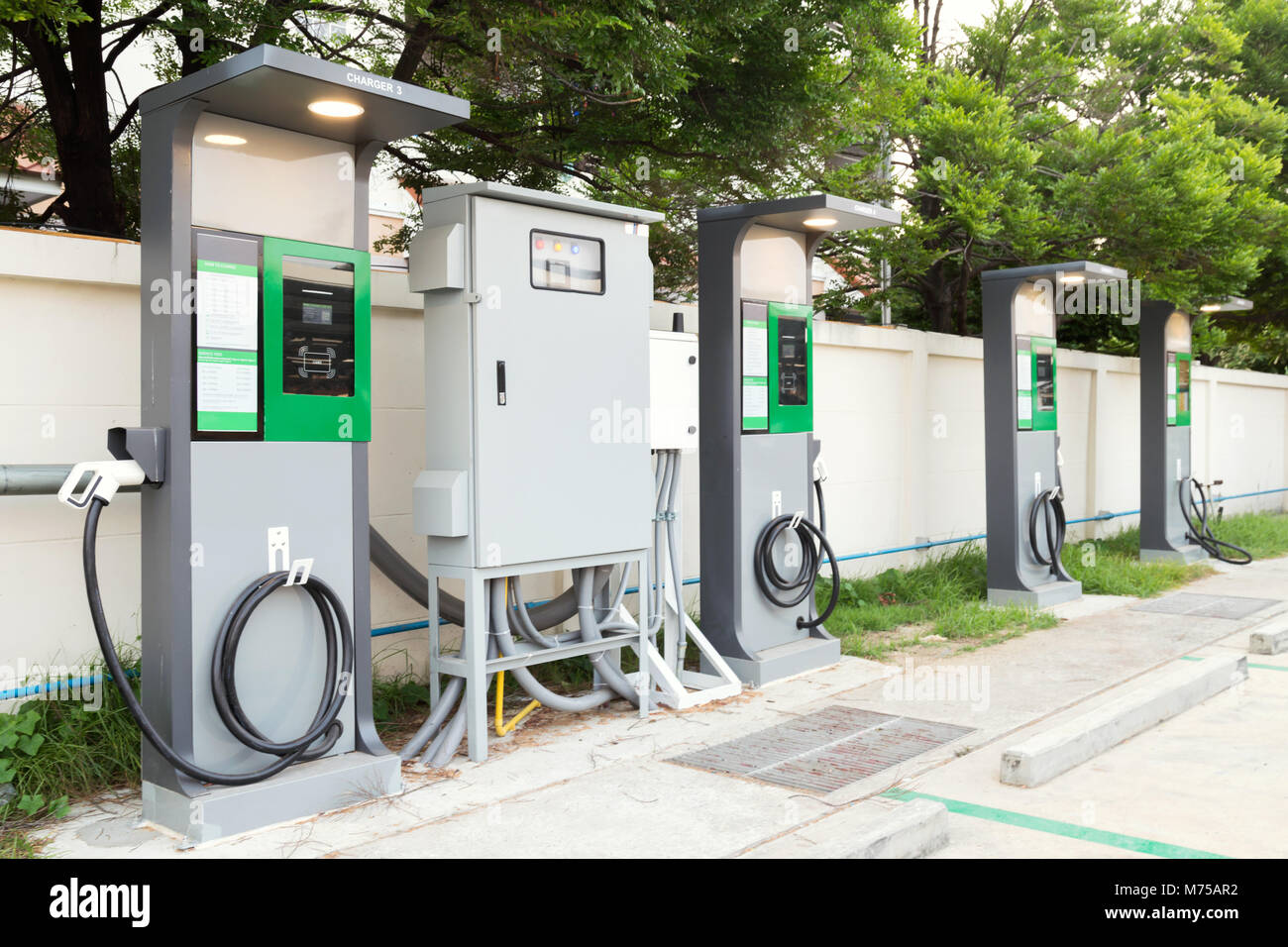 Chargeur de voiture véhicule électrique rapide avec câble branché d'alimentation et le boîtier d'alimentation à la station EV sites. Station de charge voiture EV dans parking à supermark Banque D'Images