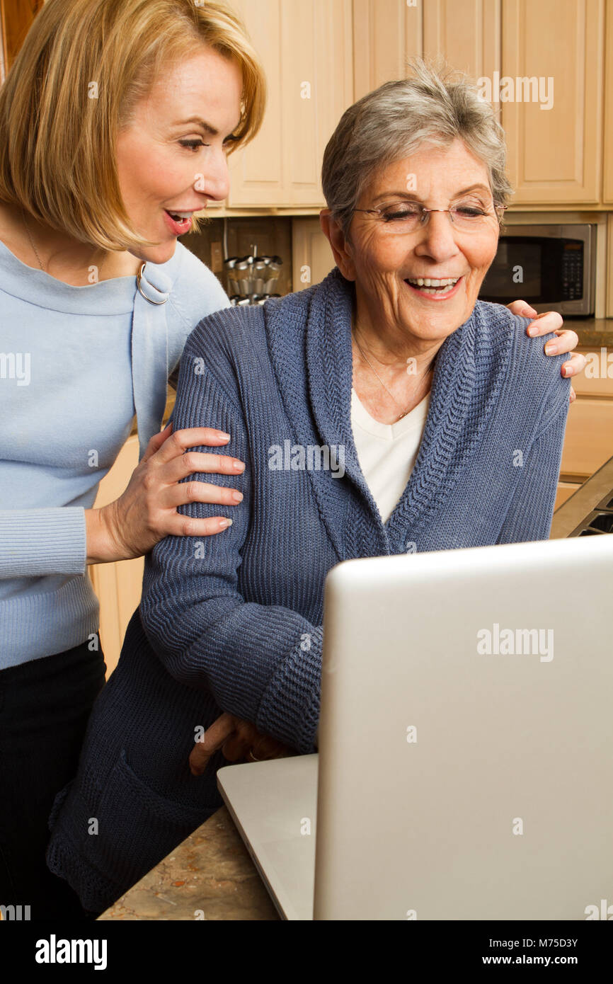 Fille aider sa mère sur l'ordinateur. Banque D'Images
