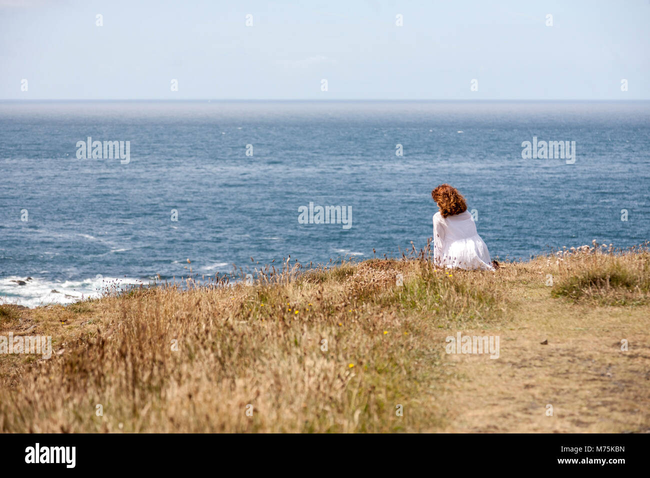 Une femme est à regarder vue paisible de la côte de Cornwall et l'horizon de Mer Celtique Banque D'Images