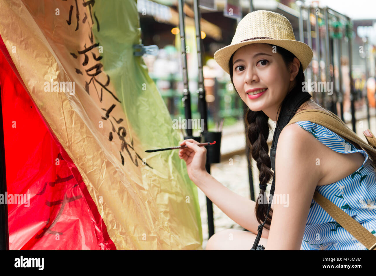 Heureux japonaise écrit leurs souhaits sur les lanternes de ciel coloré face à caméra pour Taïwan billet. Traduction sur sky lanterns texte 'espoir de wea Banque D'Images
