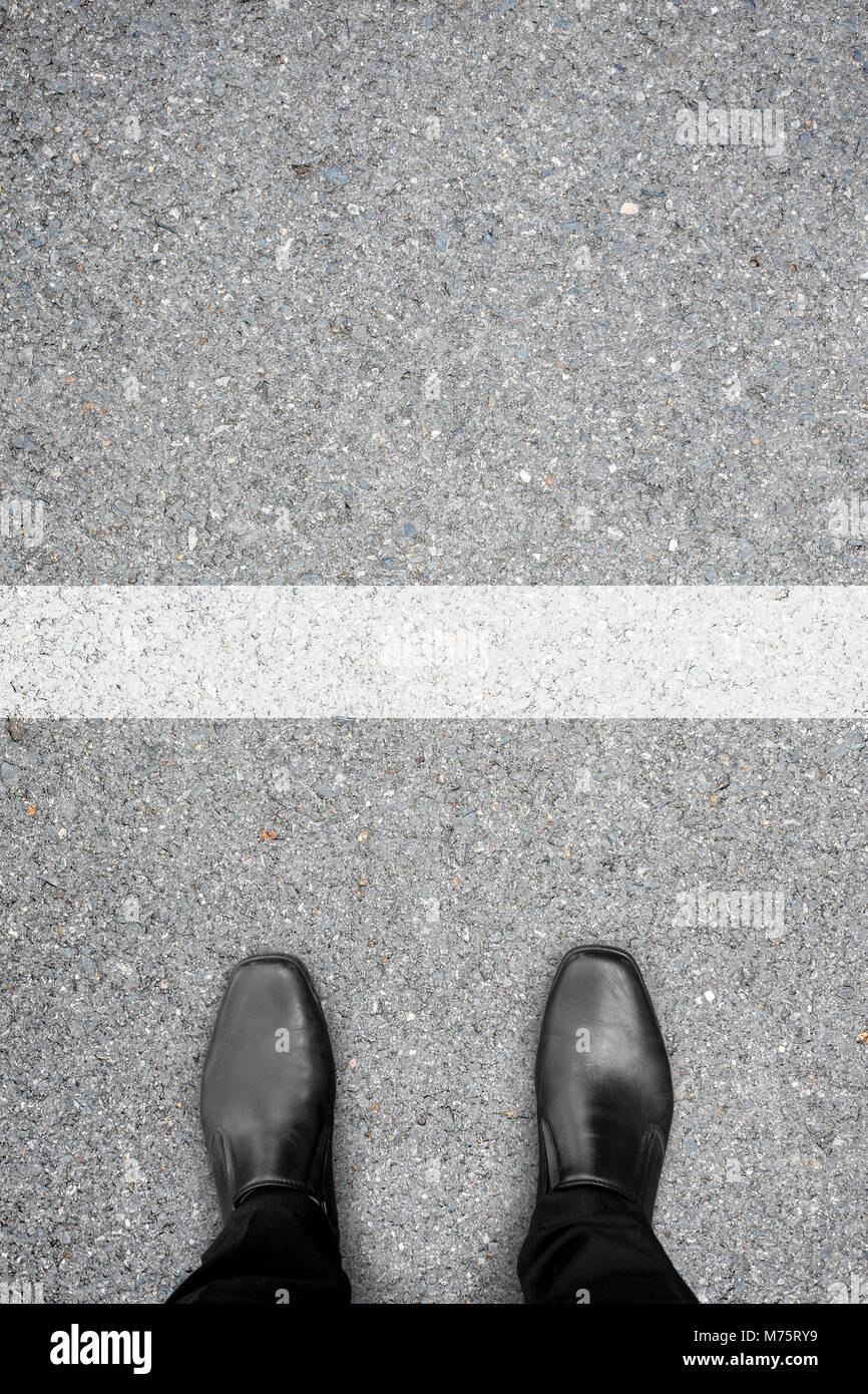 Chaussures noires debout à la ligne blanche comme c'est une limite ou frontière ligne ou ligne de démarrage/arrêt. Banque D'Images