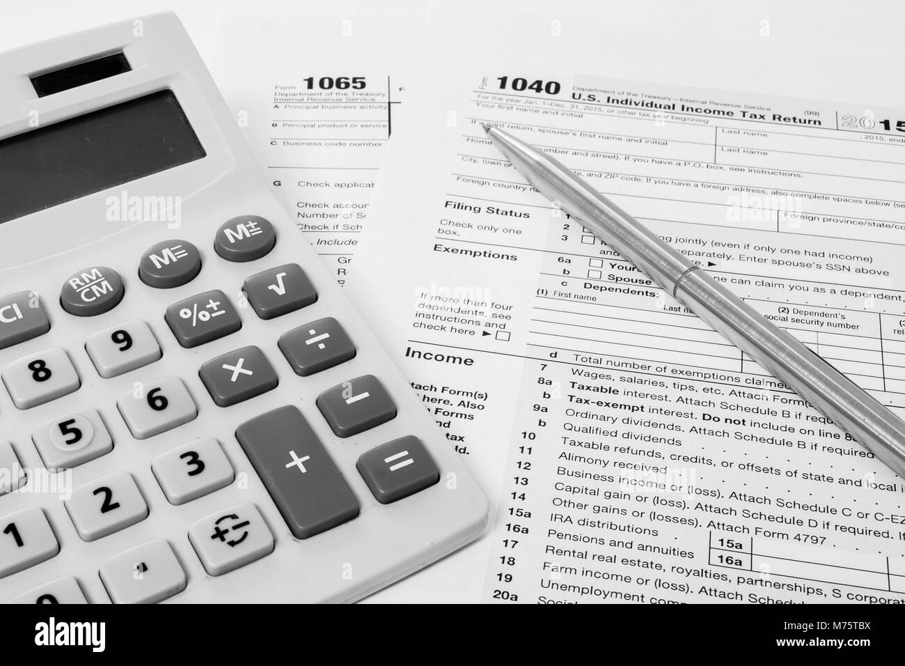 Formulaire 1040 de l'impôt américain et 1065 avec un stylo et une calculatrice Banque D'Images