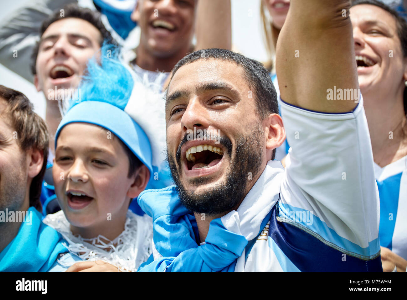 Football fans cheering at match Banque D'Images