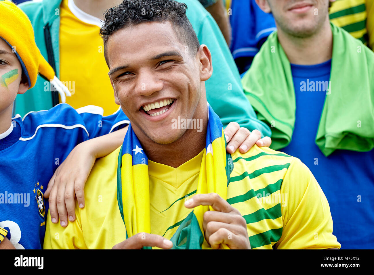 Fan de football brésilien souriant gaiement au match Banque D'Images