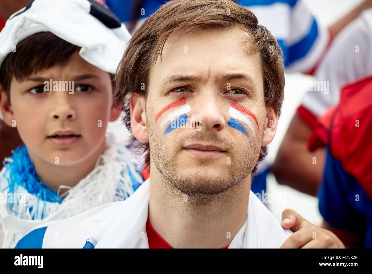 Père et fils, avec anxiété, regarder un match de football français Banque D'Images