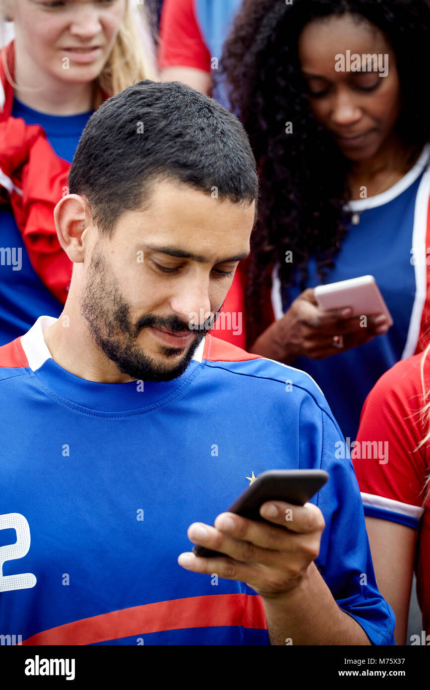 Man looking at smartphone lors de match de football Banque D'Images