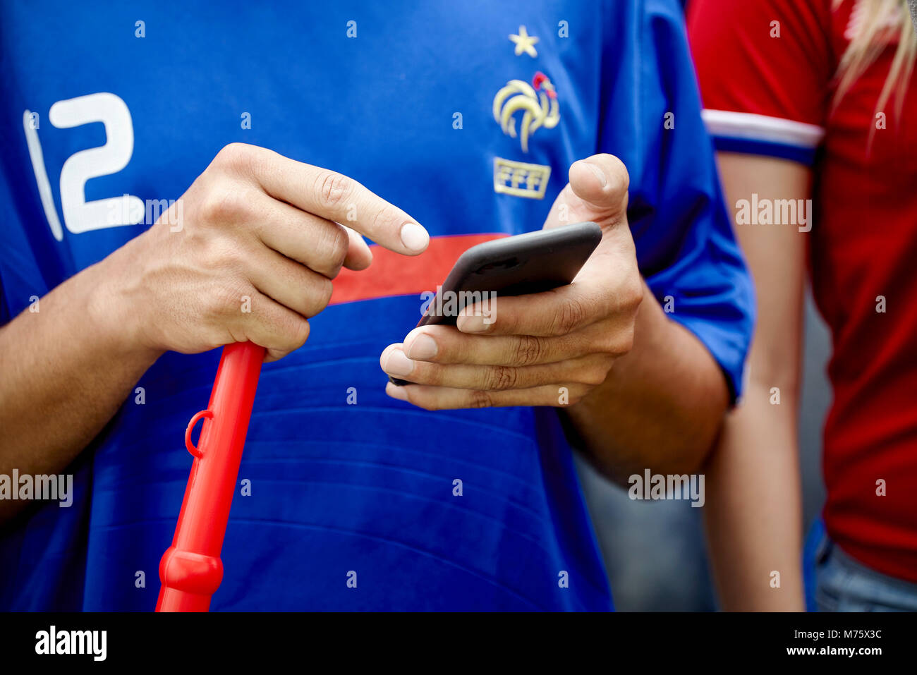 Fan de football français en utilisant smartphone à match, cropped Banque D'Images