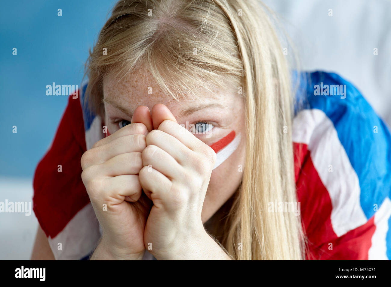 Amateur de sports match regarder avec les mains jointes avec anxiété à visage Banque D'Images