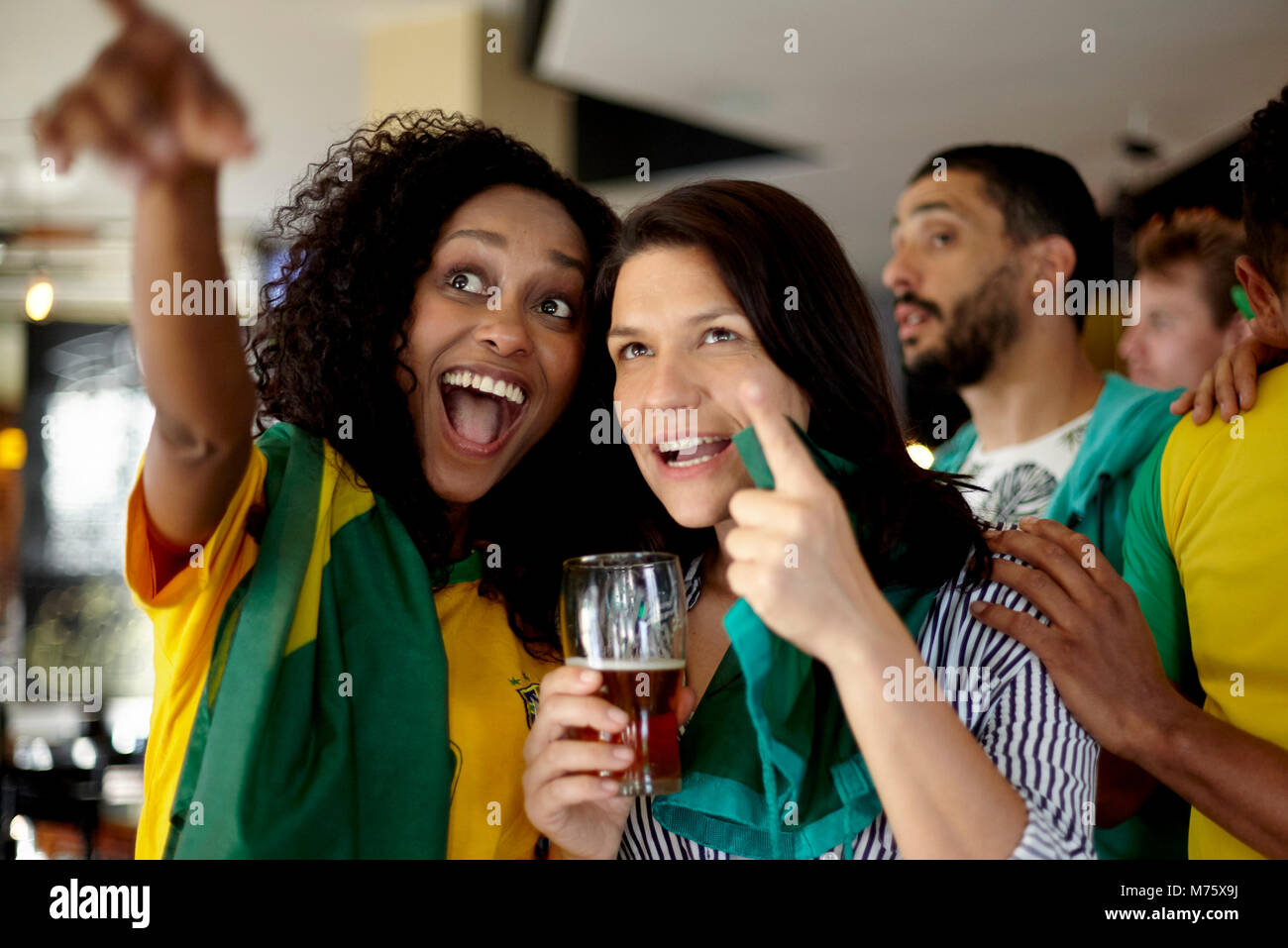 Les supporters de football brésilien regarder match en bar Banque D'Images