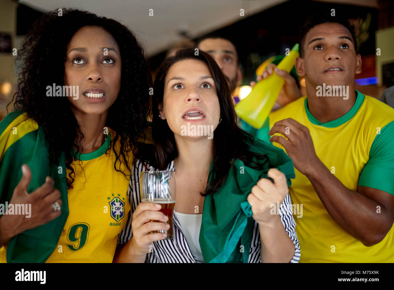 Les supporters de football brésilien regarder match en bar Banque D'Images