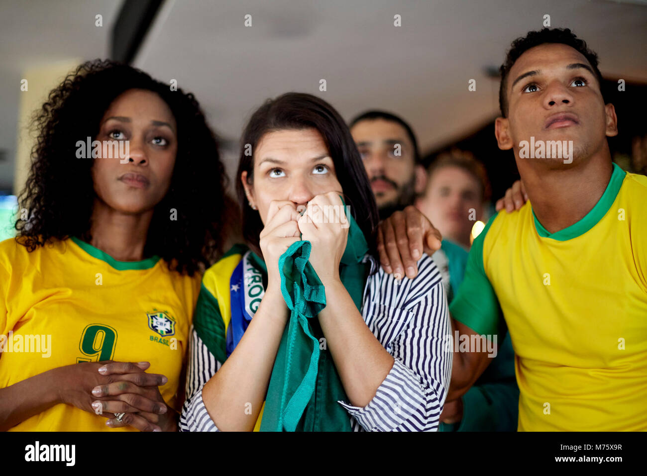 Les supporters de football brésilien regardant anxieusement match à bar Banque D'Images