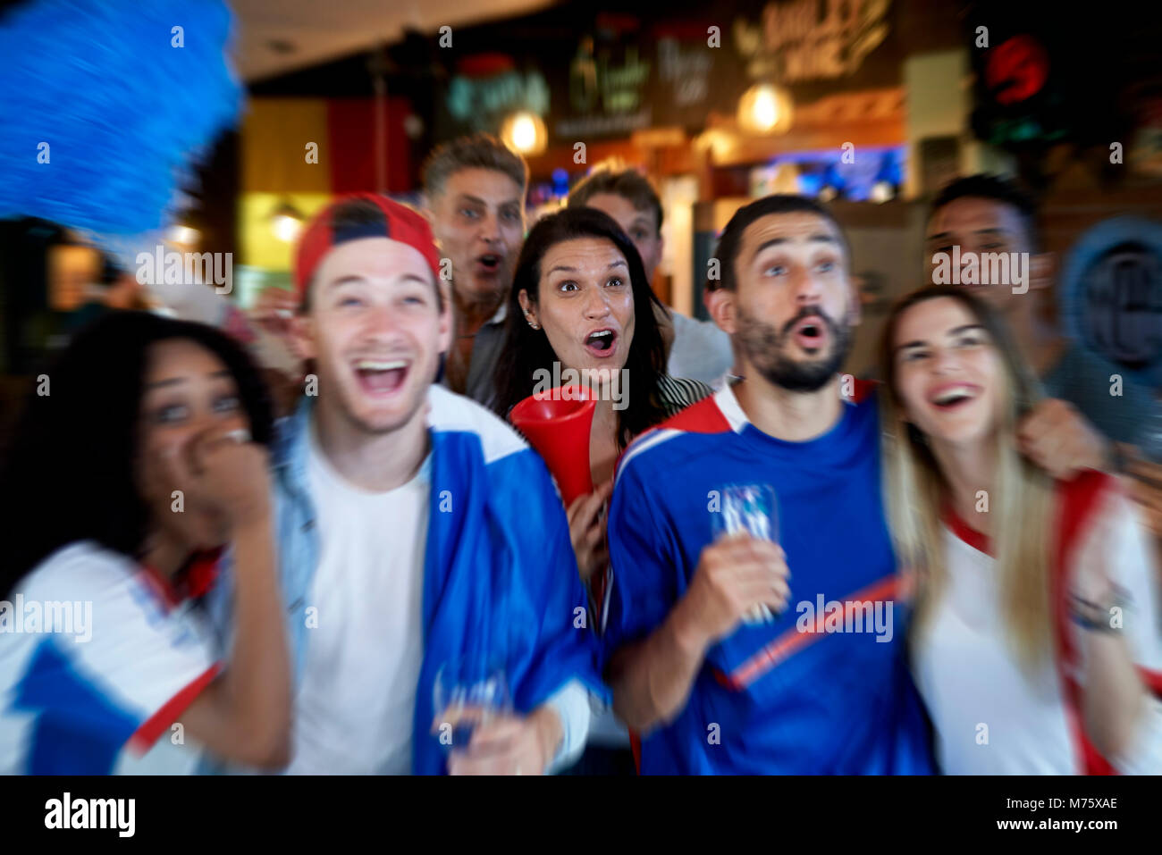 Les fans de football français regarder match de football à la télévision au pub Banque D'Images