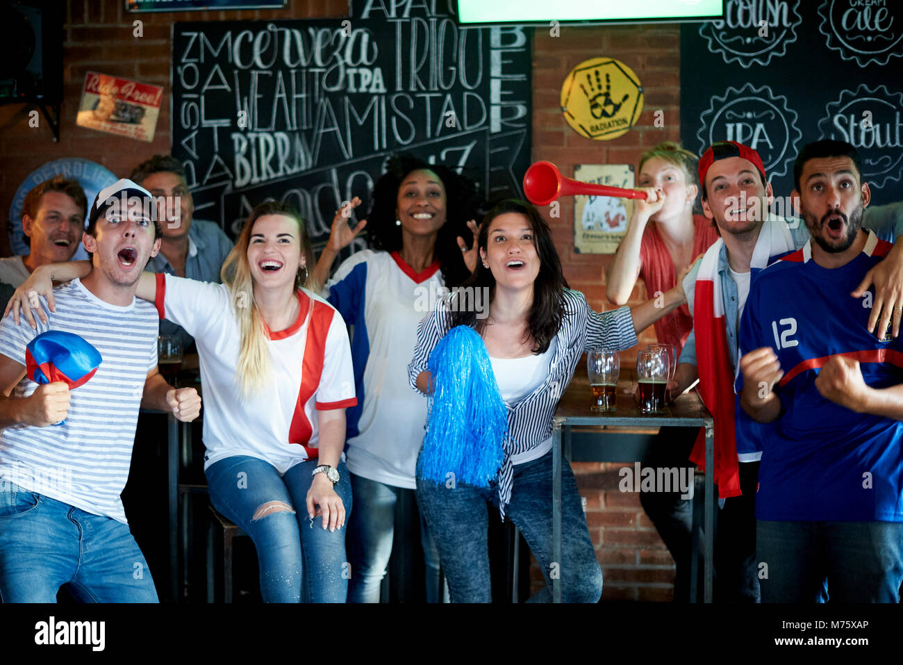 Les fans de football français regarder match de football à la télévision au pub Banque D'Images