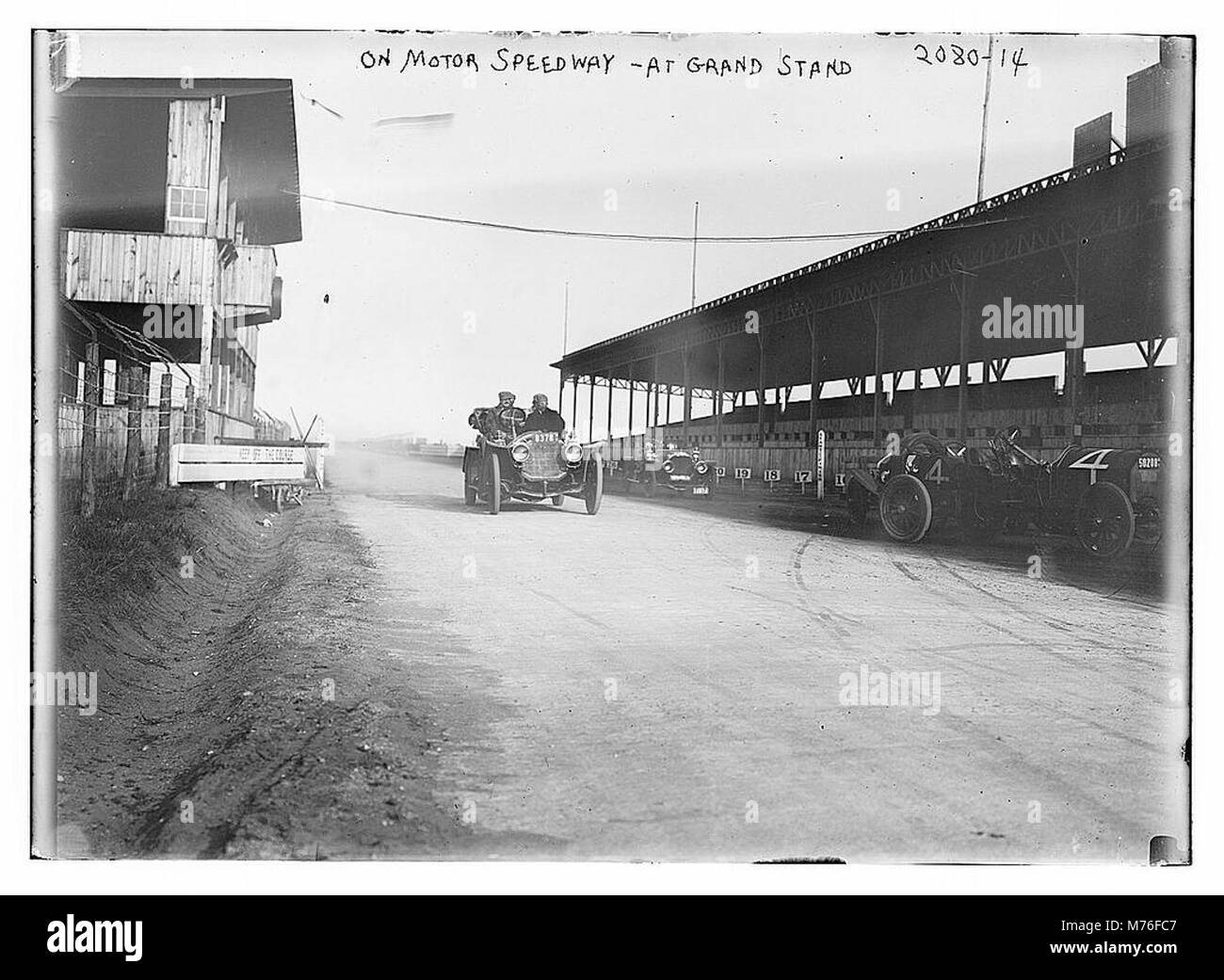 Une photographie d'un circuit automobile, montrant la tribune remplie de spectateurs. L'image représente l'excitation et l'atmosphère d'un événement majeur de sport automobile, probablement du milieu du XXe siècle. Banque D'Images