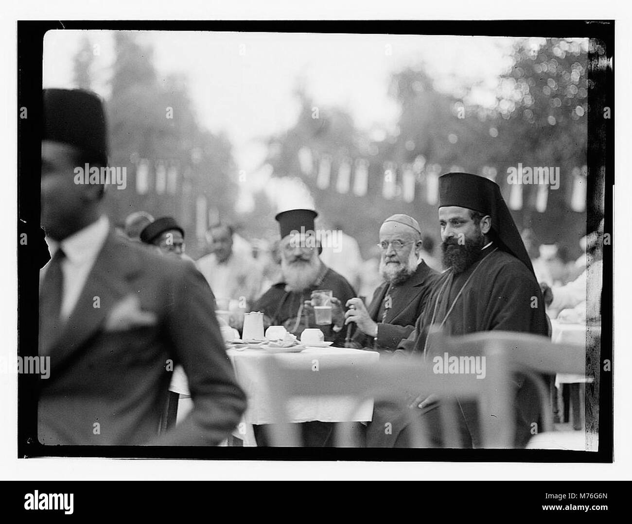 Une photographie du 6 octobre 1932, à Bagdad, montrant le grec, le russe, ou des prêtres arméniens à un événement du palais, capturant la diversité culturelle et religieuse. Banque D'Images