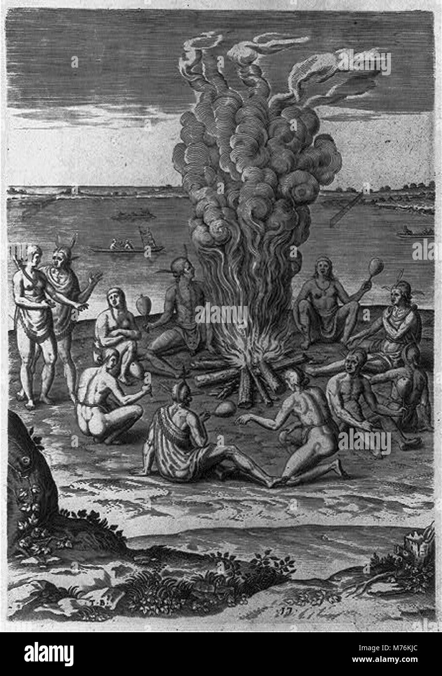 Photographie représentant un groupe d'individus priant autour d'un feu tout en utilisant des hochets, probablement dans le cadre d'une cérémonie culturelle ou spirituelle. Banque D'Images
