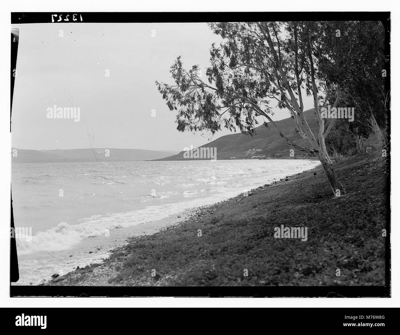Cette image représente la vue méridionale de la mer de Galilée, montrant son plan d'eau et la vue lointaine de bains anciens, reflétant l'importance historique et religieuse de la région. Banque D'Images