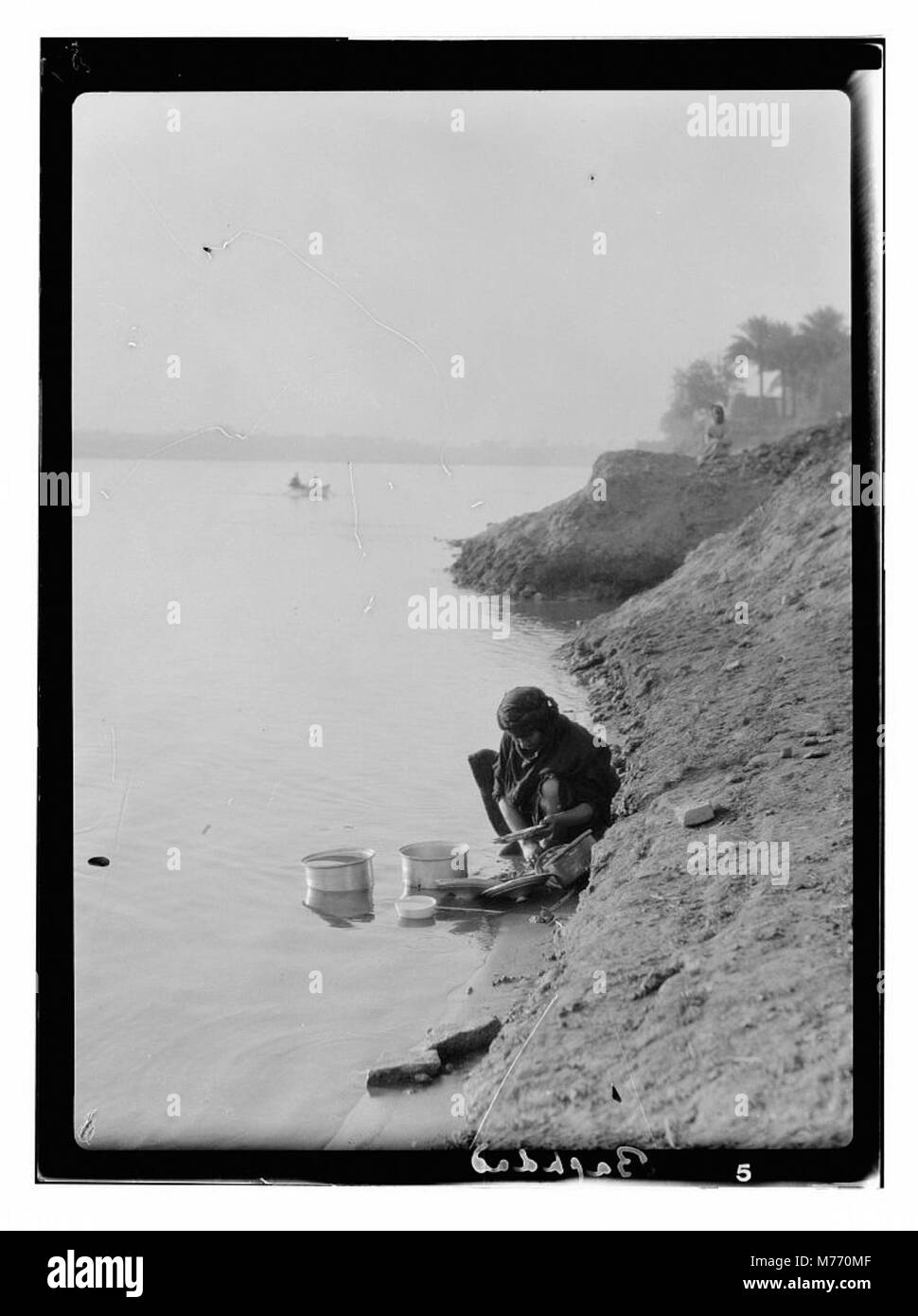 Cette image représente une scène de rue à Bagdad, montrant un environnement urbain animé en Irak avec divers bâtiments et éléments culturels. Banque D'Images
