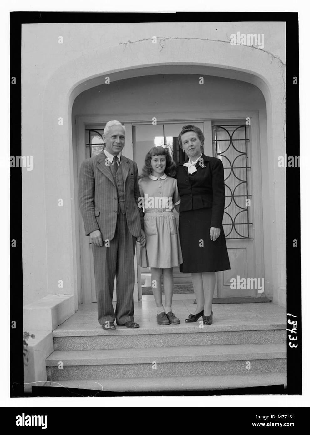 La famille Stoltzfus se tient à l'entrée principale de leur maison, capturant une vue rapprochée du côté est de leur maison. Banque D'Images