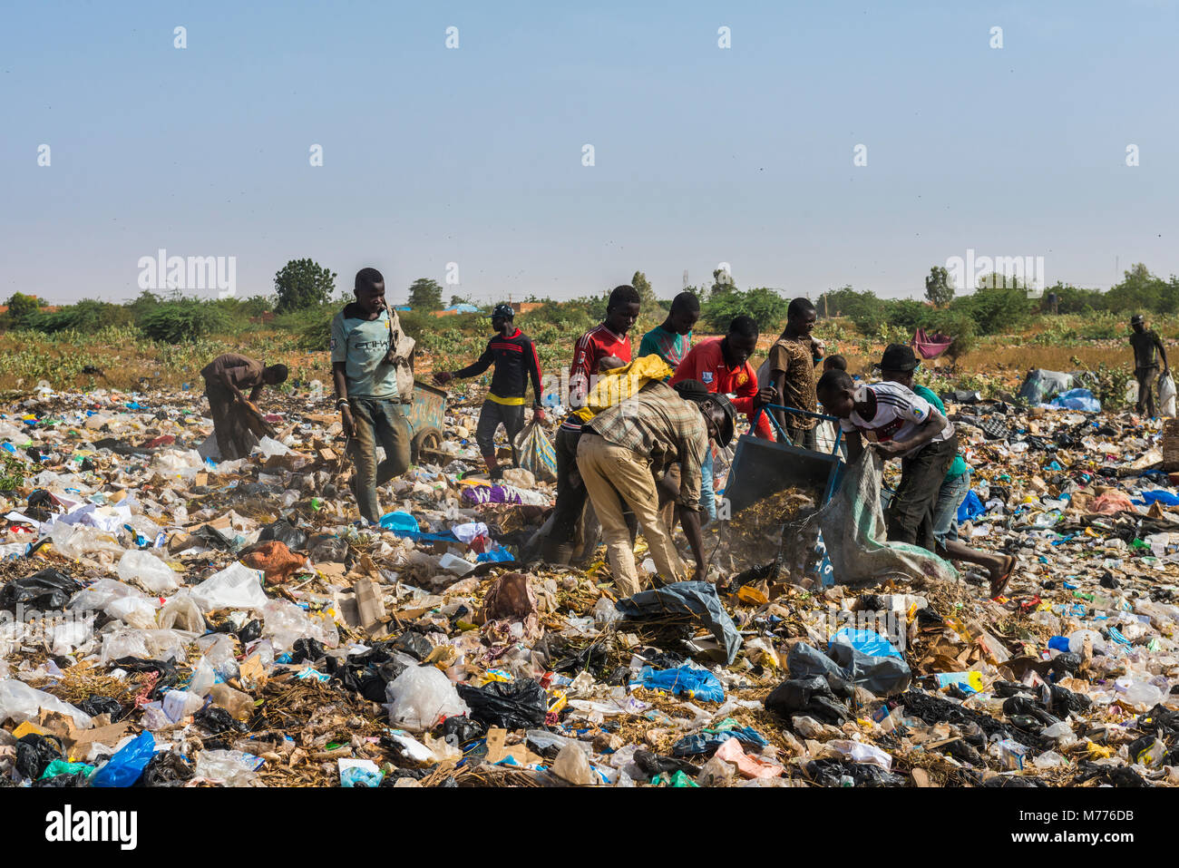 Les garçons à la recherche d'objets de valeur dans la décharge publique, Niamey, Niger, Afrique Banque D'Images