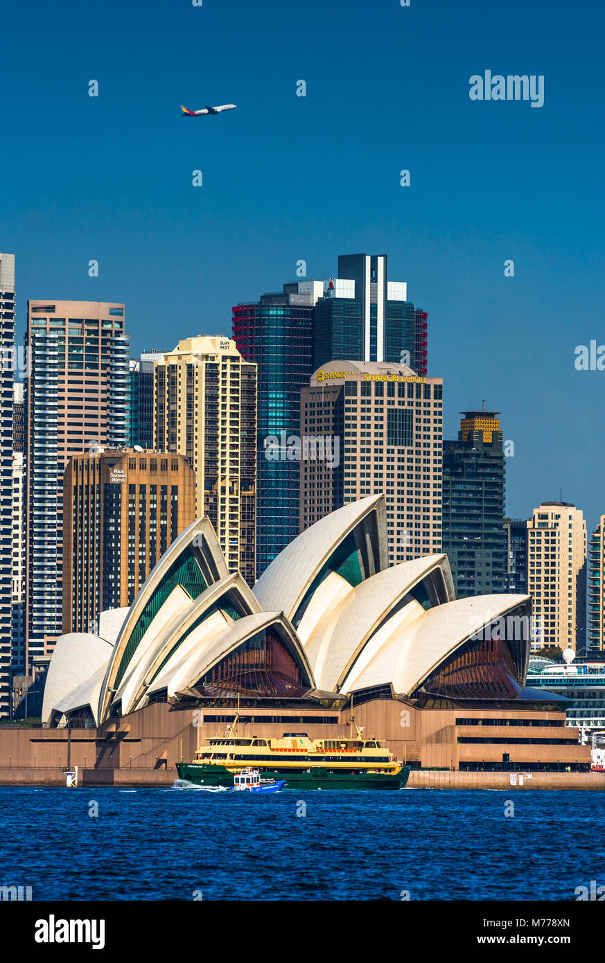 Un avion survole la ville de Sydney et de l'opéra comme un ferry et de l'eau passer par taxi, Sydney, Nouvelle-Galles du Sud, Australie, Pacifique Banque D'Images