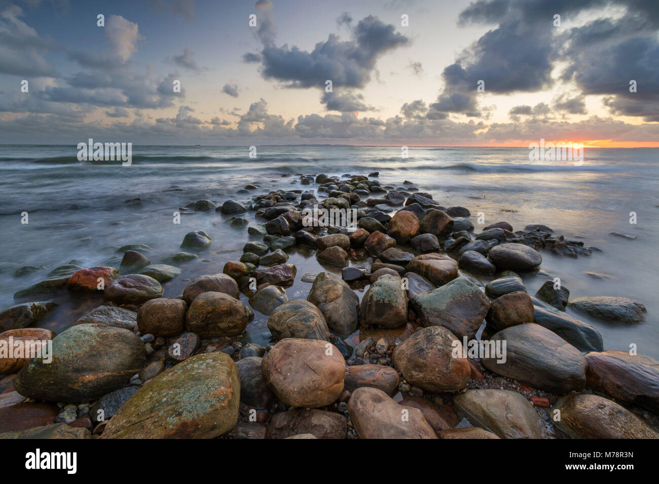 Brise-lames de pierre en mer au lever du soleil, Munkerup, le Kattegat, la Nouvelle-Zélande, le Danemark, la Scandinavie, l'Europe Banque D'Images
