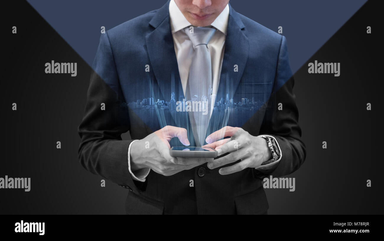 Young businessman using mobile smart phone, avec bâtiments futuristes hologram Banque D'Images