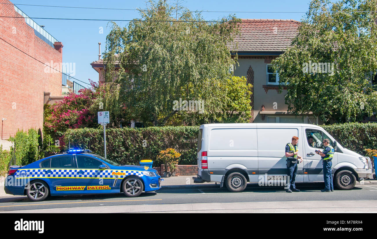 Des agents en uniforme de la patrouille routière de la Police de Victoria question un automobiliste en banlieue de Camberwell, Melbourne, Australie Banque D'Images