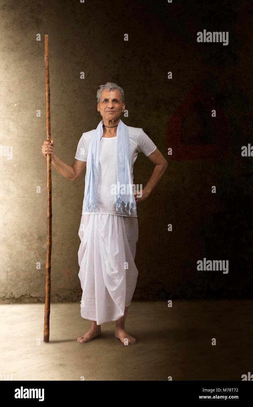 Portrait of senior farmer holding stick Banque D'Images
