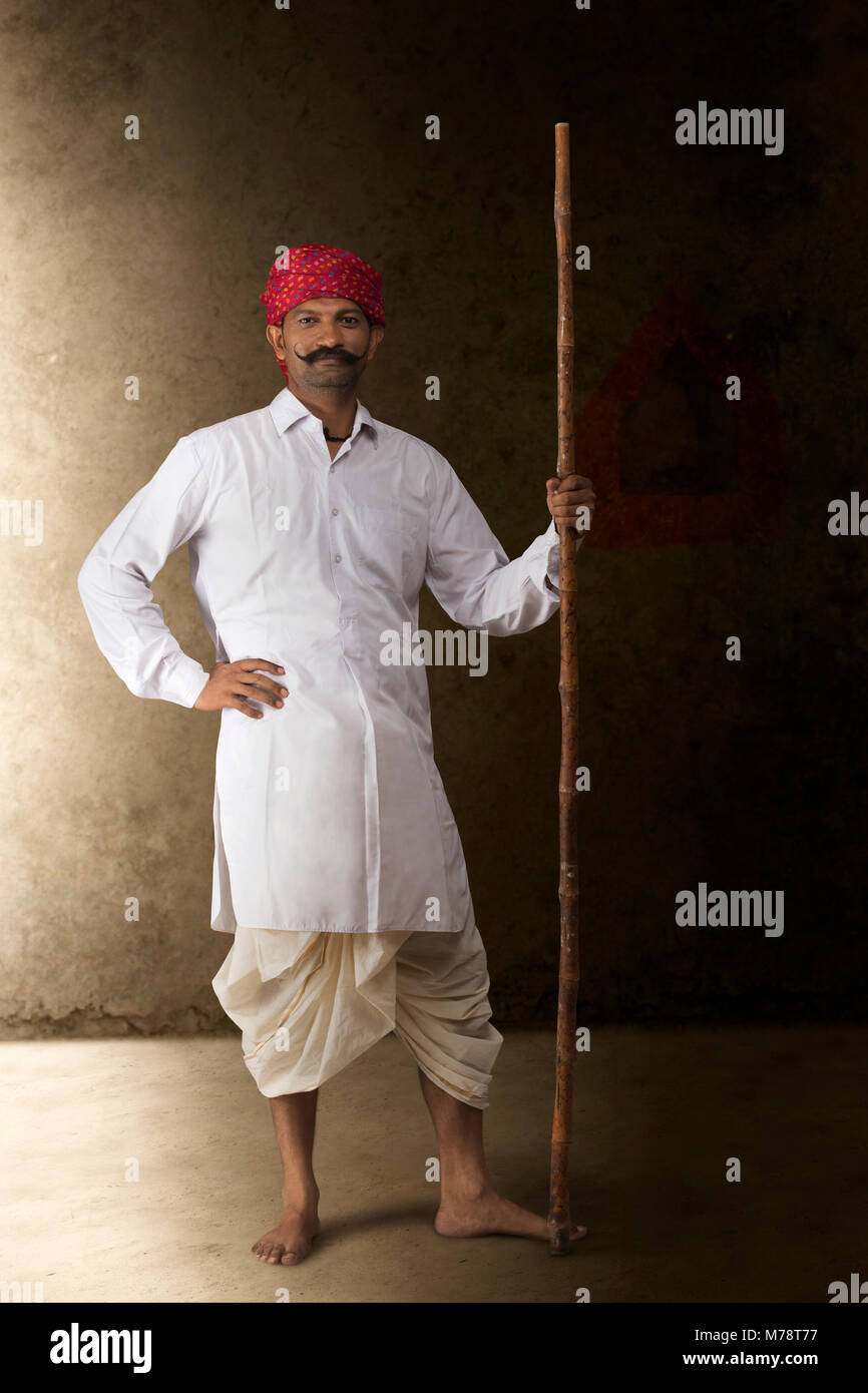 Portrait d'agriculteur en vêtements traditionnels holding stick Banque D'Images