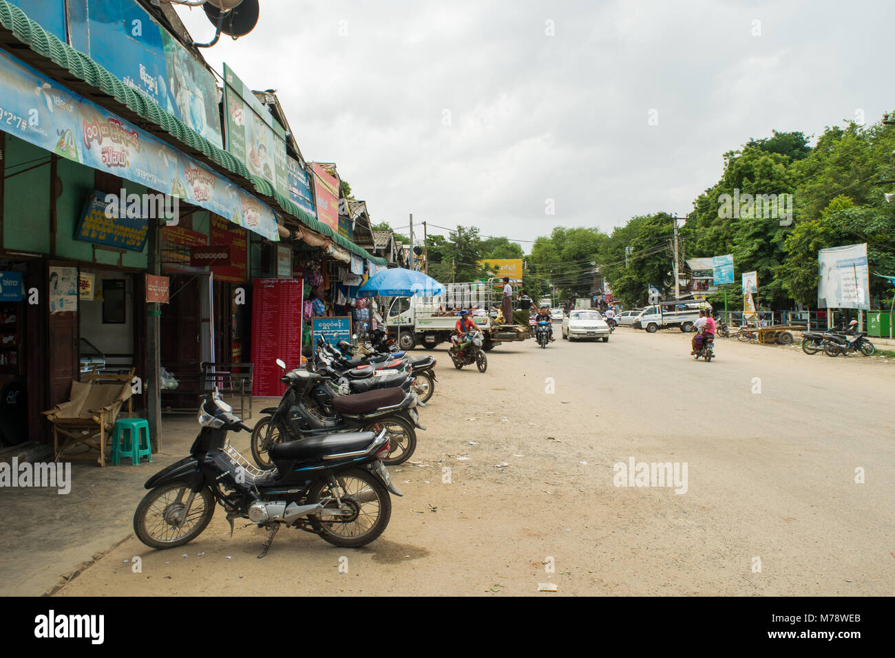 Un chemin de sable à côté du marché Nyaung U près de Bagan, Myanmar, Birmanie. étals de marché et les motos garées, mode de transport commun en Asie du sud-est Banque D'Images