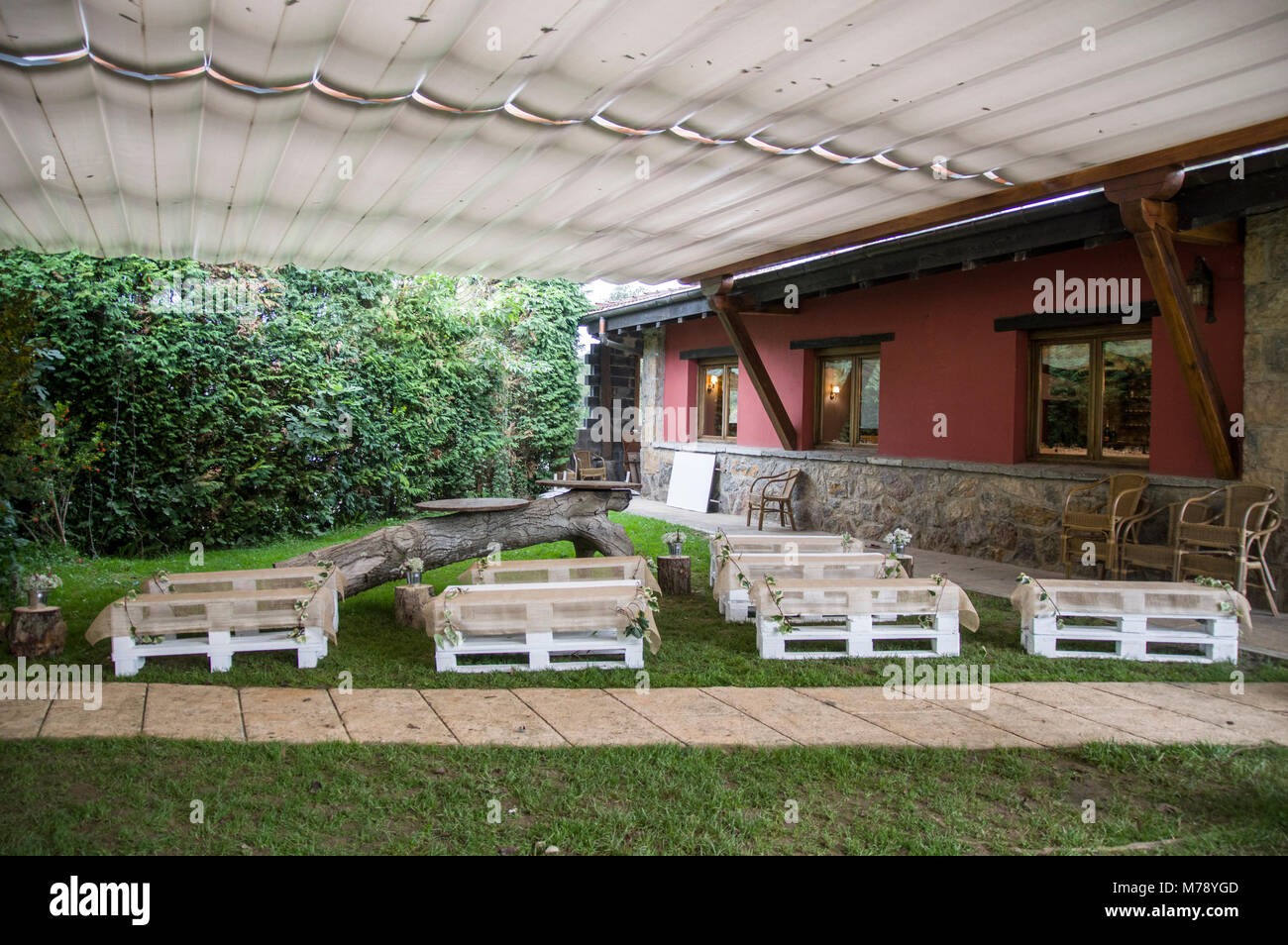 Centre jardin décoré pour son mariage avec des bancs en bois dans le Jai Alai restaurant, Urrestilla, Pays Basque, Espagne Banque D'Images
