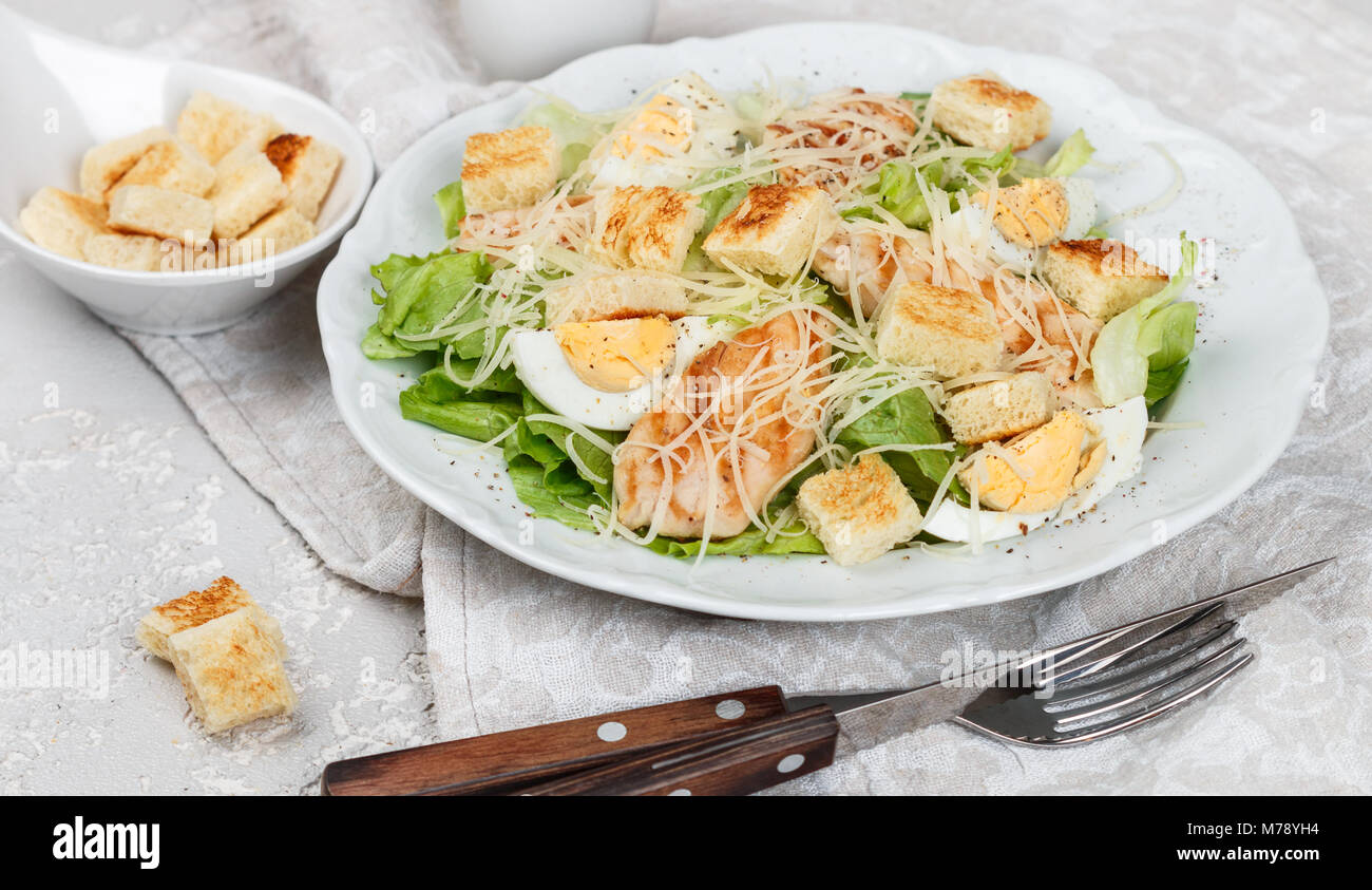 Salade césar avec poulet grillé, salade, oeuf, fromage et croûtons à l'ail dans une assiette blanche. Selective focus Banque D'Images