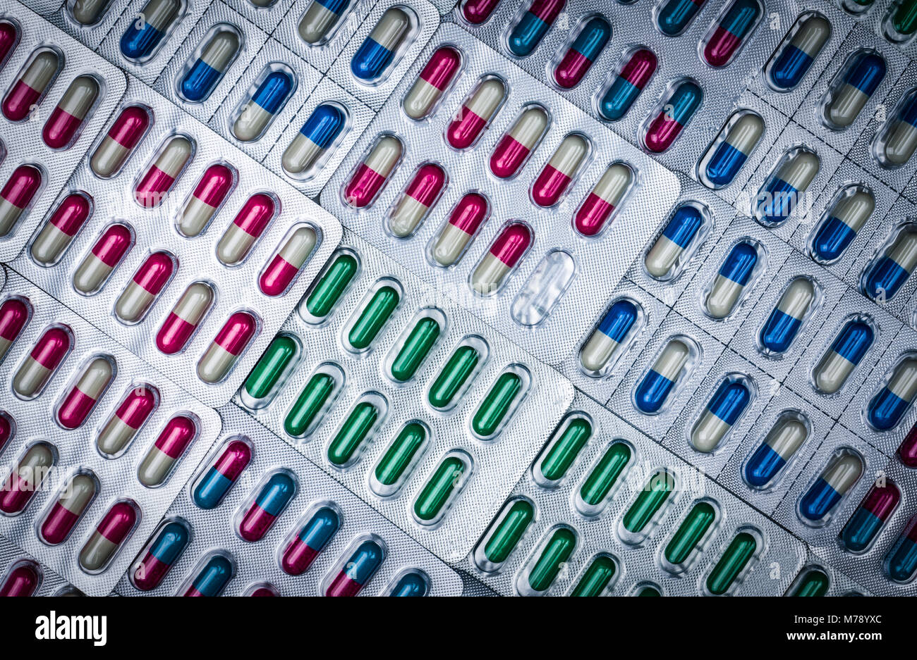 Image complète de pilules colorées capsule aux antimicrobiens. Erreur de contrôle de la qualité dans la fabrication de produits pharmaceutiques. Blister manque une gélule d'antibio Banque D'Images