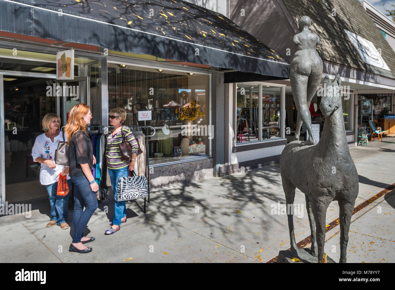 Les femmes à l'entrée du magasin, le cheval et le cavalier sculpture par Philip Maior, l'Art au coin de la rue principale, au programme commercial de Grand Junction, Colorado, USA Banque D'Images