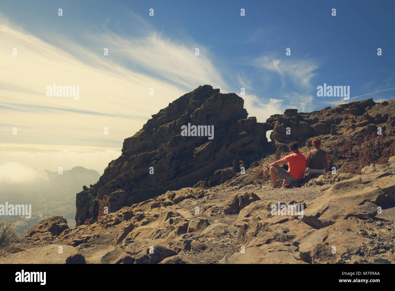 Deux touristes d'âge mûr assis sur les montagnes rocheuses de l'île de Gran Canaria. Banque D'Images