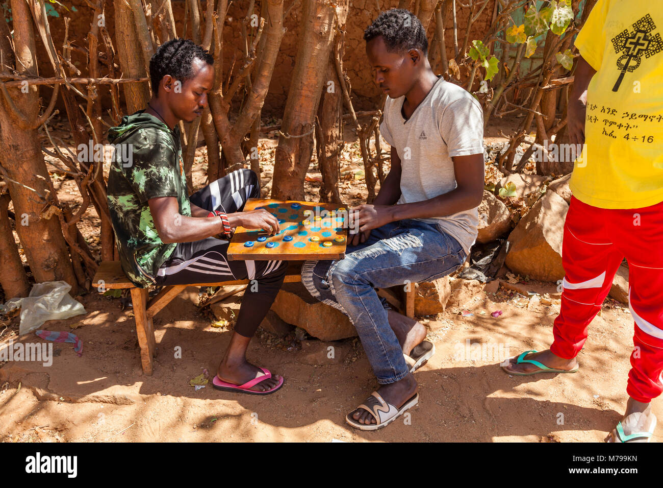 Deux jeunes hommes jouent des brouillons (dames) à l'aide de bouteilles, Dimeka, vallée de l'Omo, Ethiopie Banque D'Images