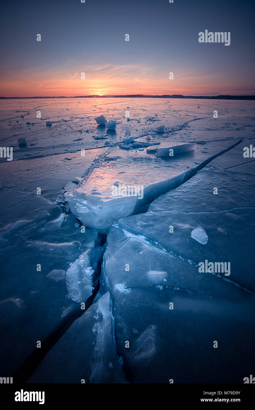 Vue paysage de fissures dans la glace de mer au coucher du soleil d'or Banque D'Images