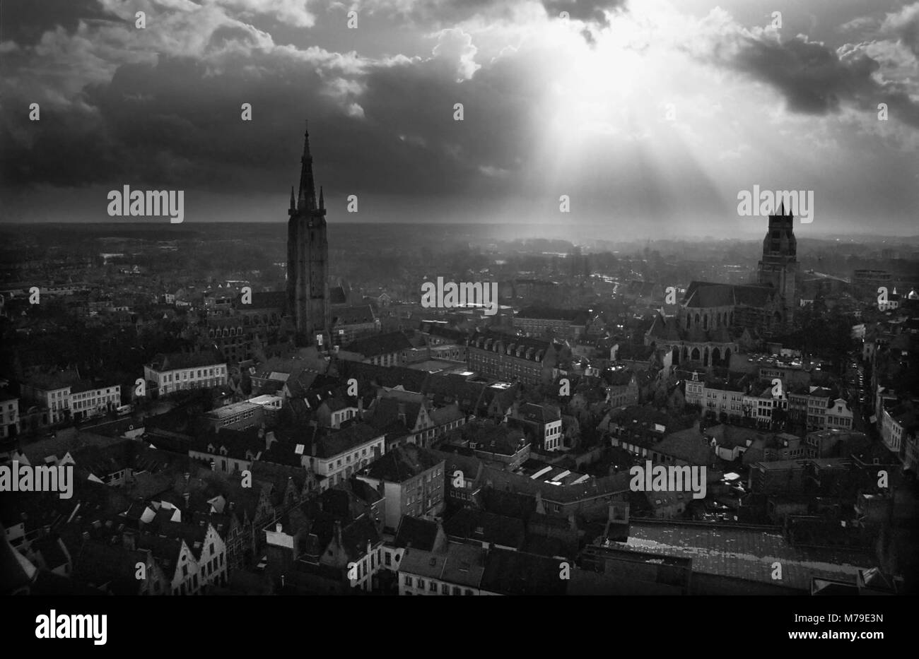 Vue aérienne sur la ville du Beffroi, Brugge, Belgique : un ciel dramatique avec le soleil percer les nuages. Film en noir et blanc photographie, vers 1985 Banque D'Images