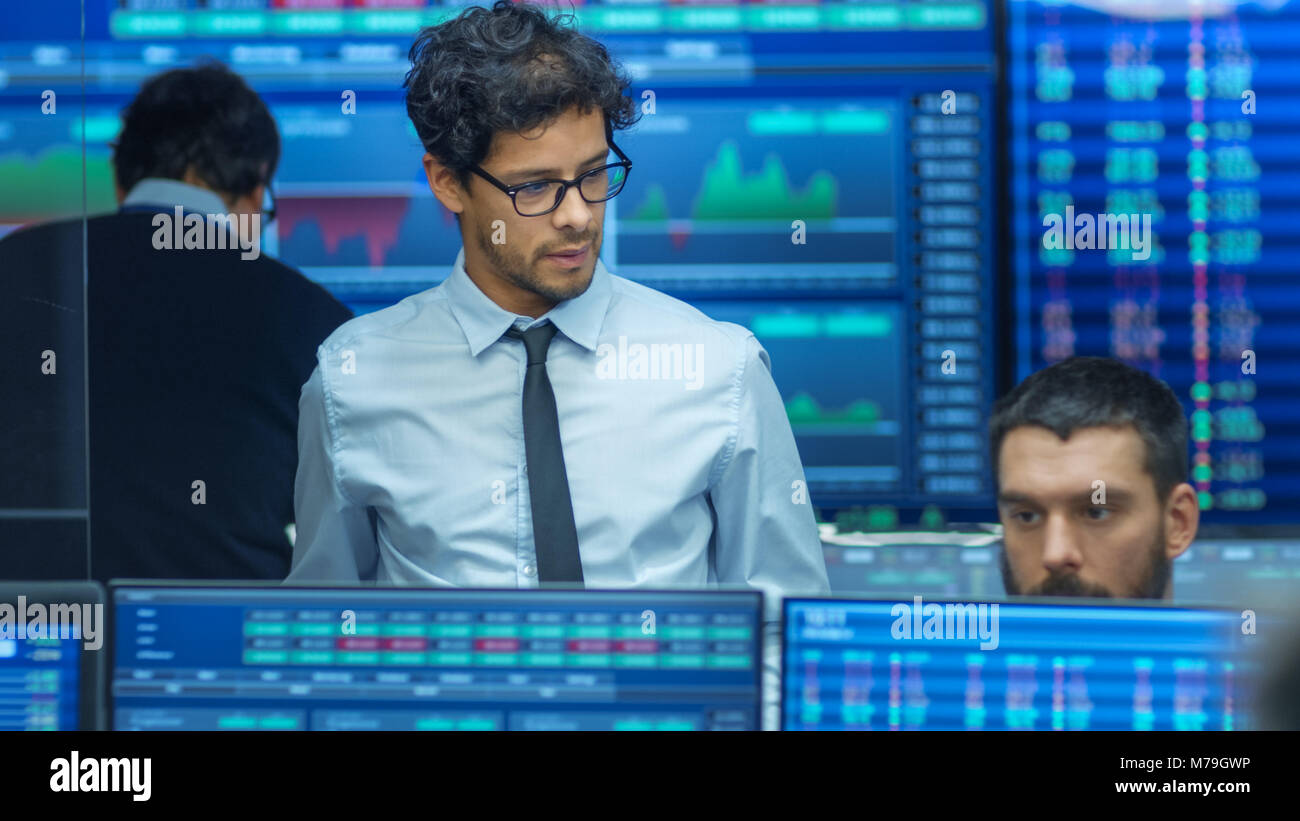 Inspecte Stock Trader d'autres travaux et discuter avec d'autres. Bureau occupé avec l'équipe Multi de courtiers, les courtiers. Affichages indiquent les chiffres et l'Infographie. Banque D'Images