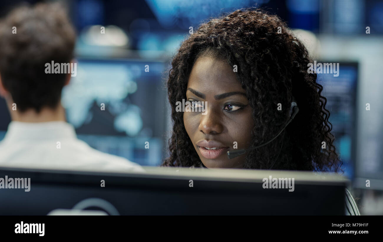 Female Customer Service Representative répondre à ses questions dans un casque. Il travaille pour une grande entreprise de technologie. Bureau a l'équipe Multi Banque D'Images